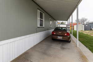 View of parking with a carport and a storage unit