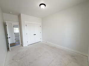 Unfurnished bedroom featuring baseboards and a closet