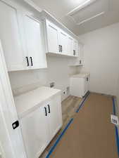 Laundry area with washer hookup, cabinet space, and wood finished floors