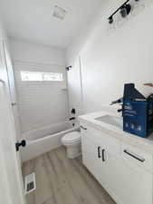 Bathroom featuring vanity, light wood-type flooring, and  shower combination