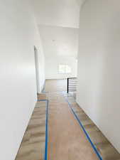 Corridor featuring light wood-style floors and lofted ceiling