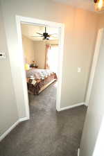 Bedroom featuring ceiling fan and dark colored carpet