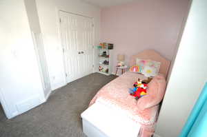 Bedroom featuring dark carpet and a closet