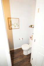 Bathroom with dark wood-type flooring and toilet