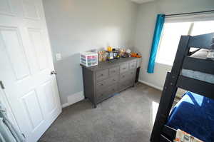 Bedroom with baseboards and light colored carpet