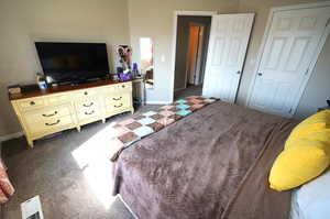 Bedroom featuring dark colored carpet and baseboards