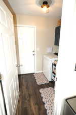 Laundry area with dark wood-type flooring and washer and dryer