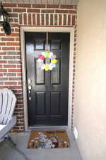 Entrance to property featuring brick siding