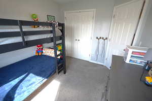 Carpeted bedroom with a closet