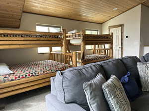 Bedroom with a vaulted wood ceiling and carpet