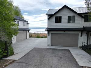 Garage featuring concrete driveway and a water view