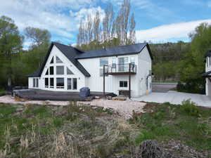 Rear view of house with a metal roof and a deck