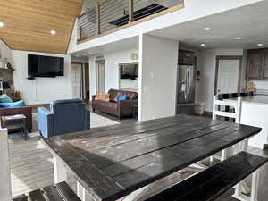 Dining room with recessed lighting, dark wood-type flooring, a fireplace, and a vaulted wooden ceiling