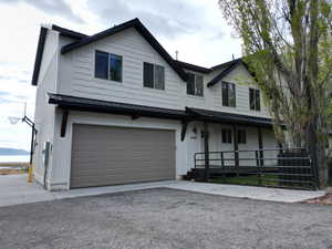 Modern farmhouse style home with a metal roof, an attached garage, covered porch, and driveway