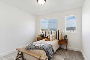 Bedroom with baseboards and light carpet