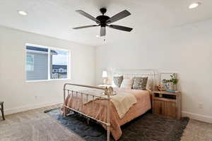 Bedroom with dark carpet, ceiling fan, and recessed lighting