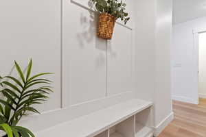 Mudroom with light wood-style flooring and baseboards