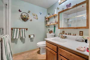Bathroom with vanity, an enclosed shower, and a textured ceiling