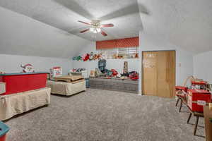 Carpeted bedroom featuring a textured ceiling and ceiling fan