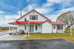 View of front of house featuring a patio, a metal roof, and a front lawn