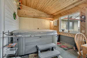 Enclosed Patio room with a hot tub, a vaulted wood walls and ceiling