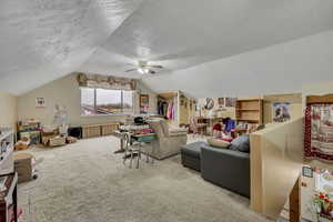 Large bedroom featuring a textured ceiling, light carpet, and ceiling fan