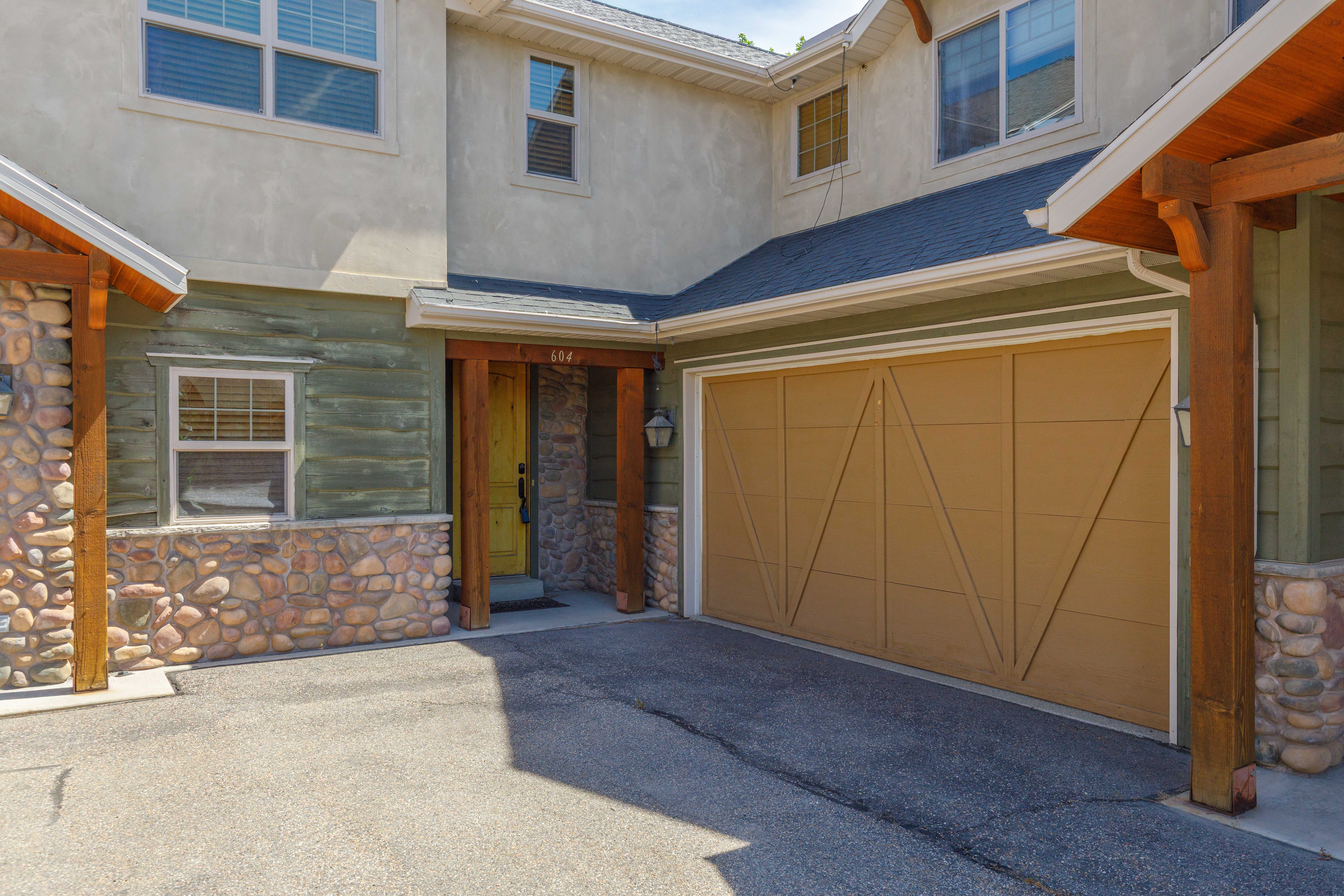 Exterior featuring a two-car garage, stucco siding, and stone accents