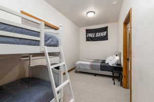 Bedroom featuring light colored carpet and baseboards