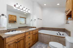 Full bathroom featuring double vanity, a garden tub, recessed lighting, and light tile patterned flooring