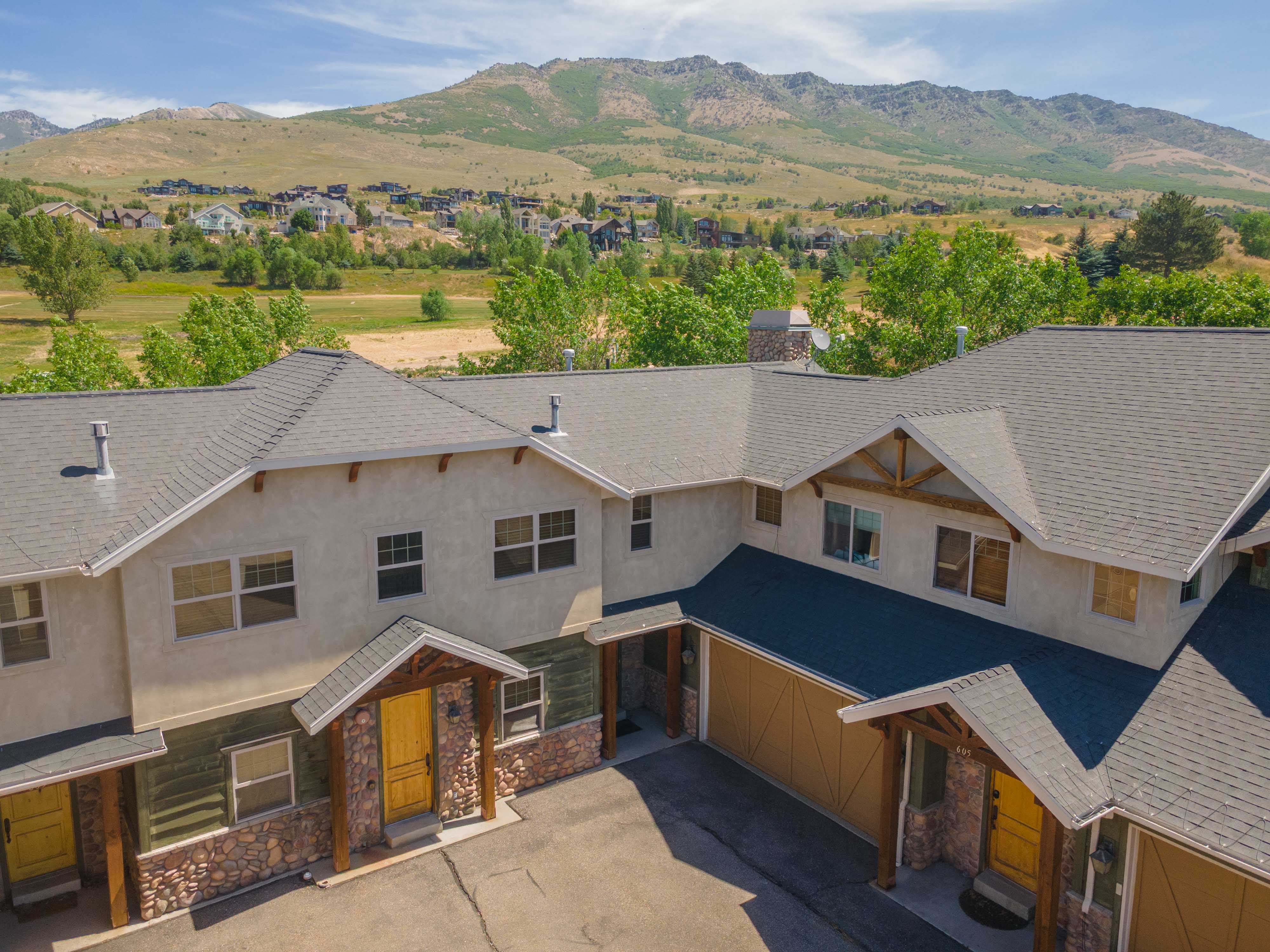 Mountainous backdrop with properties featuring stone veneer and wood accents