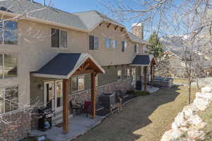 View of front of property with a hot tub, a shingled roof, a patio area, and a chimney