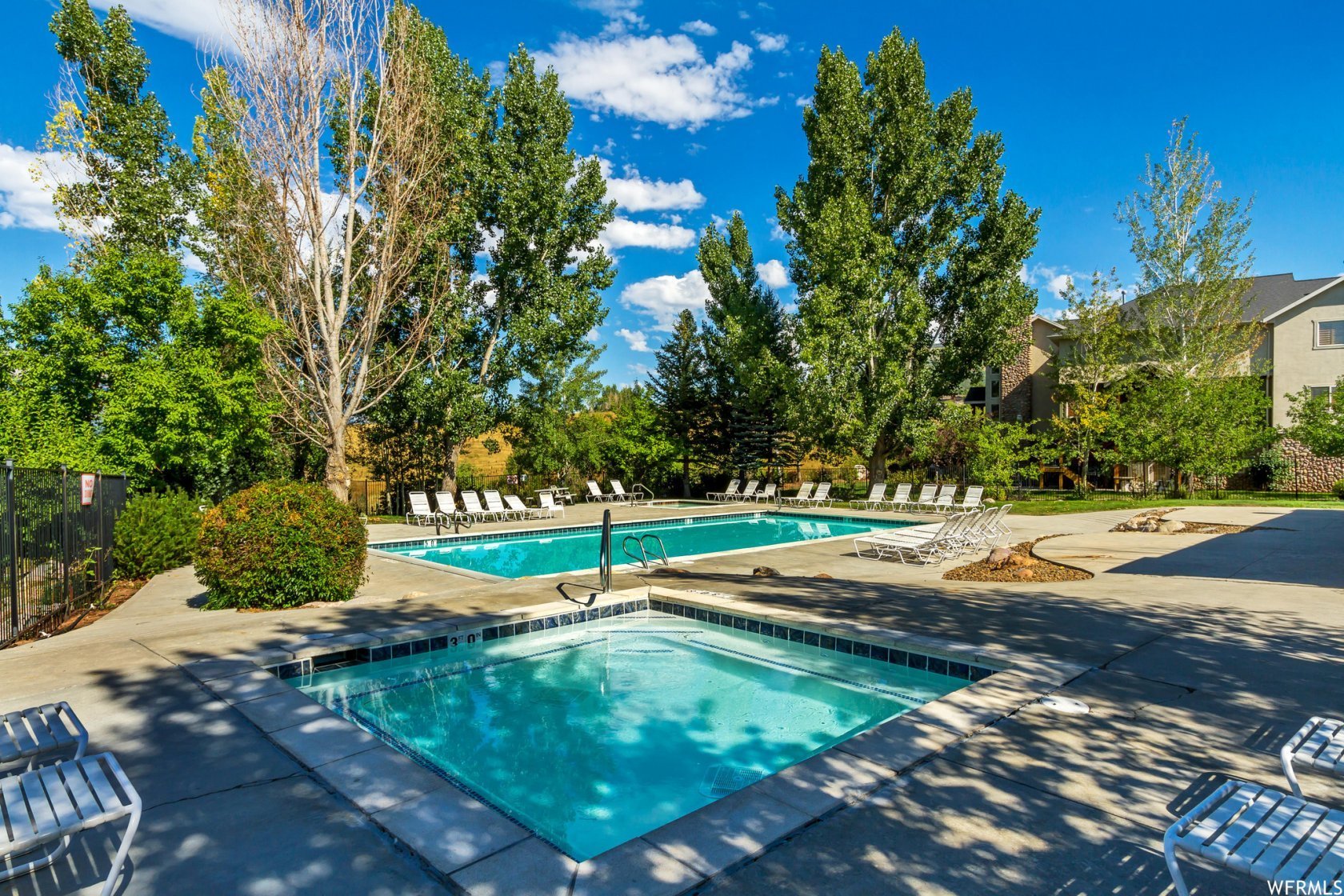 Community pool featuring a patio and a hot tub