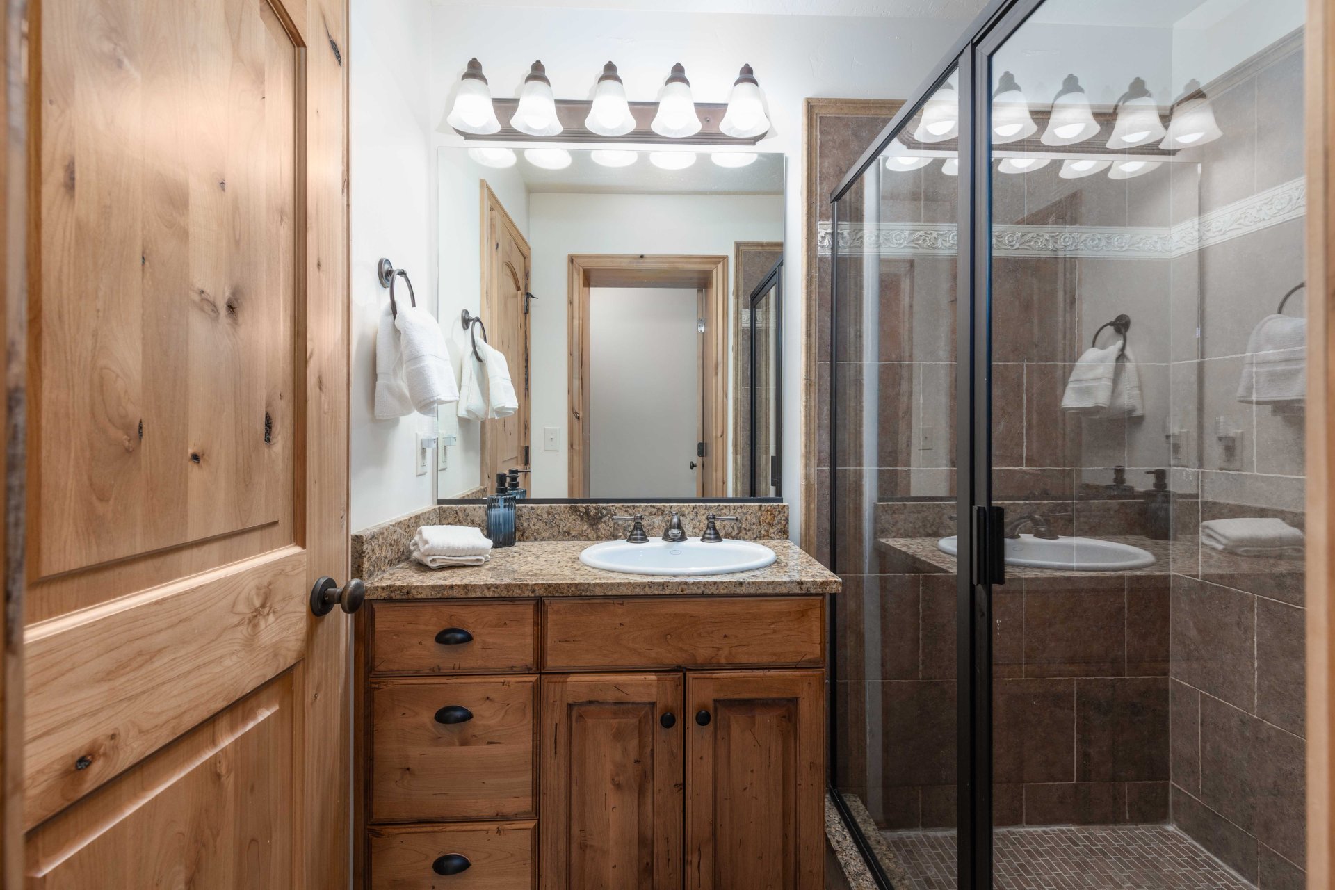 Full bathroom with vanity and a shower stall
