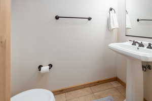 Bathroom with light tile patterned flooring and toilet