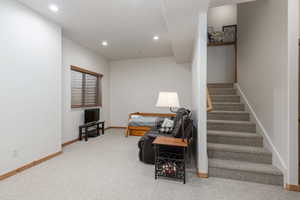 Living area with light colored carpet and recessed lighting