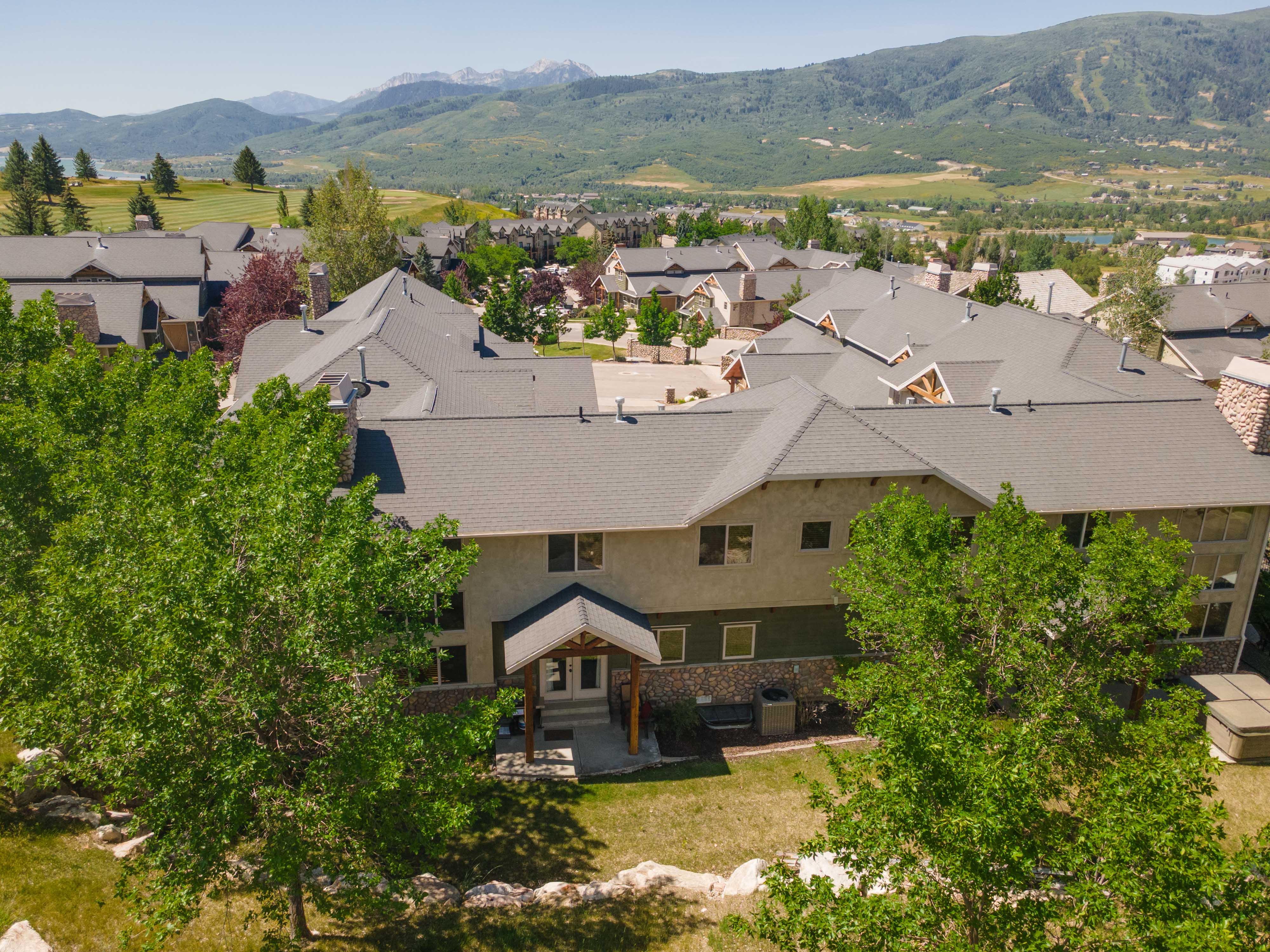Multi-story property featuring a stone and stucco exterior with multiple gables