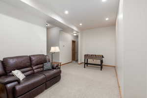 Living room with light colored carpet and recessed lighting