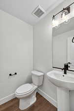 Half bathroom featuring baseboards and dark wood-type flooring