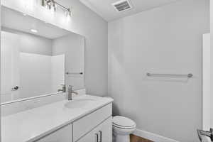 Bathroom featuring vanity, dark wood finished floors, and a shower