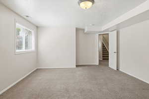 Unfurnished bedroom featuring a textured ceiling, carpet floors, and a closet
