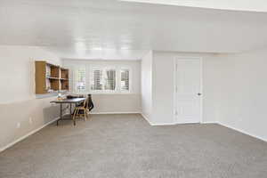 Basement family room with a textured ceiling and carpet