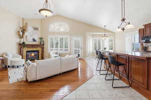 Family area with light tile patterned flooring, a premium fireplace, and lofted ceiling