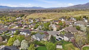 Aerial view of property and surrounding area featuring a mountain backdrop and nearby suburban area
