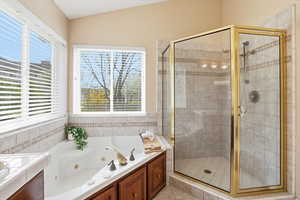 Bathroom with a shower stall, a tub with jets, and vaulted ceiling