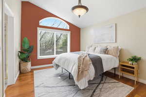 Bedroom featuring lofted ceiling and wood finished floors