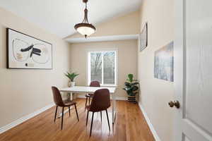 Home office with lofted ceiling and wood finished floors