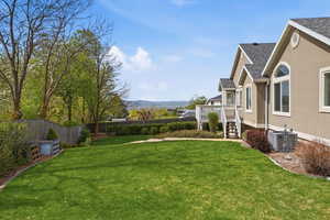 Fenced backyard with a deck with mountain view and stairs