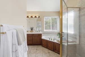 Bathroom with vanity, a garden tub, a shower stall, and light tile patterned flooring