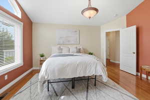 Bedroom with vaulted ceiling and light wood-type flooring
