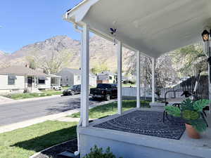 Covered porch with a residential view and a mountain view